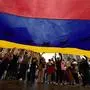 TOPSHOT - People display a giant Venezuelan flag as they celebrate in Medellín, Colombia, on January 3, 2026, after US forces captured Venezuelan leader Nicolas Maduro. President Donald Trump said Saturday that US forces had captured Venezuela's leader Nicolas Maduro after bombing the capital Caracas and other cities in a dramatic climax to a months-long standoff between Trump and his Venezuelan arch-foe. (Photo by JAIME SALDARRIAGA / AFP)