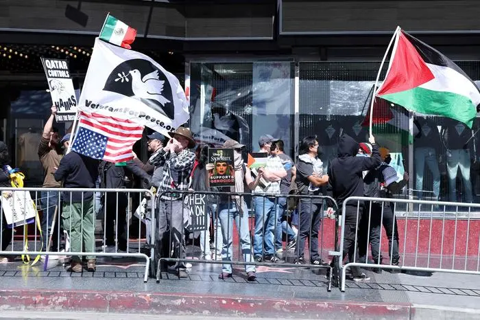 Pro-Israel and pro-Palestinian people protest in front of the El Capitan Theater during Israeli actress Gal Gadot's Hollywood Walk of Fame Star Ceremony in Los Angeles, California, on March 18, 2025. (Photo by VALERIE MACON / AFP)