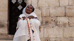 Eine äthiopische Pilgerin betet vor der Grabeskirche in Jerusalem, der heiligsten Stätte der Christenheit