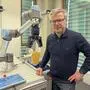Hubert Zangl, Leiter des Instituts für Intelligente Systemtechnologien an der Uni Klagenfurt | Hubert Zangl führt vor, dass der Robotergreifer dank Sensor auch mit Trinkbechern umgehen kann
