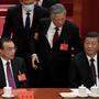 Hu Jintao (Mitte) wurde von seinem Platz neben Staatschef Xi Jinping (rechts) vom Podium geführt. 