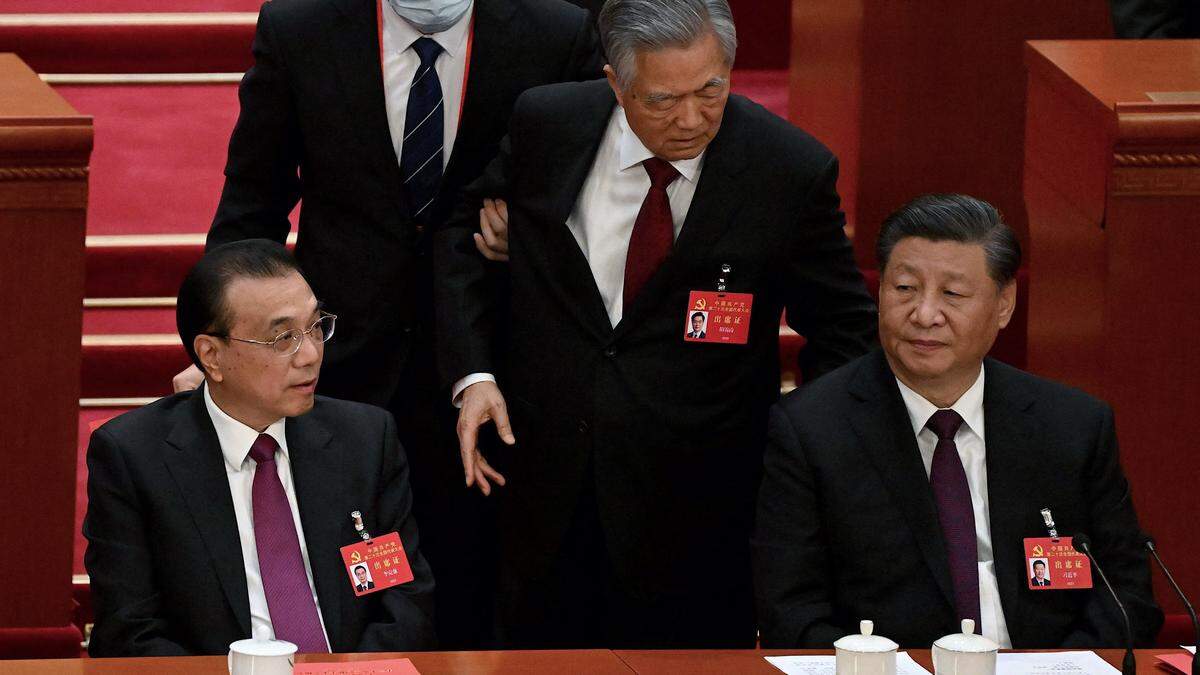 Hu Jintao (Mitte) wurde von seinem Platz neben Staatschef Xi Jinping (rechts) vom Podium geführt. 
