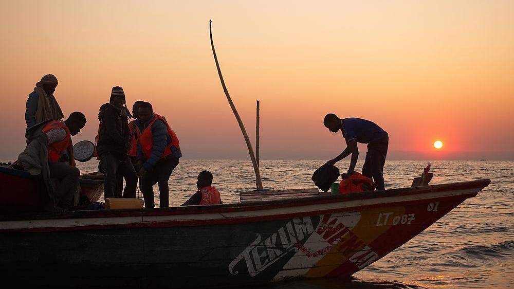 Sambische Fischer hoffen in der Abendsonne auf einen guten Sardinenfang.