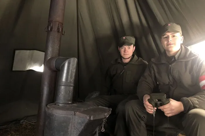Die Soldaten im Gelände können sich zum Ausruhen und Aufwärmen in ein Zelt zurückziehen. Es wird von einem kleinen Holzofen beheizt.