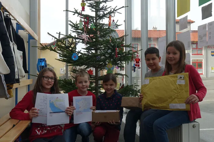 Die Schüler haben die Ehre und dürfen die Packerln aufmachen.