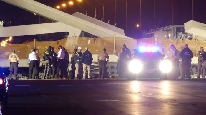 Eine 950 Tonnen schwere Fußgängerbrücke, die nagelneu war, sackte am Donnerstag plötzlich in ganzer Länge von etwa 53 Metern zusammen und fiel auf die darunterliegende, siebenspurige Straße.