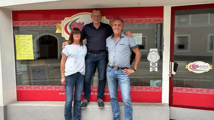 Zwei Männer und eine Frau sehen vor einem Schaufenster