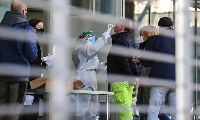 Residents gather to undergo a free rapid antigen nasopharyngeal swab test for COVID-19 at a testing facility on November 20, 2020 in Bolzano, South Tyrol, Northern Italy, during a three-day mass screening test session performed by health care personnel and proposed to the whole population of South Tyrol in facilities throughout the region. (Photo by PIERRE TEYSSOT / AFP)
