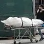 A body is moved from a refrigeration truck serving as a temporary morgue to a vehicle at the Brooklyn Hospital Center, in the Borough of Brooklyn on April 8, 2020 in New York. - New York recorded a new single-day high for coronavirus deaths on April 8, but Governor Andrew Cuomo said the epidemic appeared to be stabilizing. Cuomo said 779 people had died in the last 24 hours, bringing the total death toll in New York state from COVID-19 to 6,268. (Photo by Bryan R. Smith / AFP)
