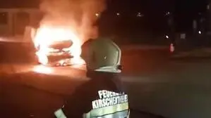 Ein Feuerwehrmann vor dem brennenden Auto | Das Auto brannte vollkommen aus