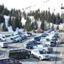 Viele Autos auf einem großen Parkplatz, dahinter ein winterlicher Wald | Bei Schönwetter sind die Parkplätze am Dobratsch oft überfüllt