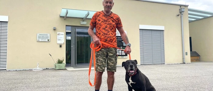 Zu sehen ist ein Mann, der einen Hund an der Leine hält 