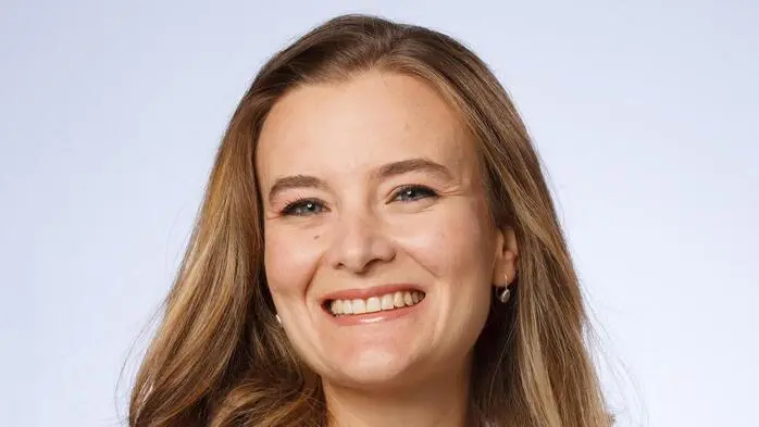 Eine Porträtaufnahme einer jungen Frau. Sie lächelt in die Kamera.