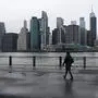 NEW YORK CITY, NY - MARCH 28: People walk in Brooklyn while lower Manhattan looms in the background on March 28, 2020 in New York City, NY. Across the country schools, businesses and places of work have either been shut down or are restricting hours of operation as health officials try to slow the spread of COVID-19. Spencer Platt/Getty Images/AFP