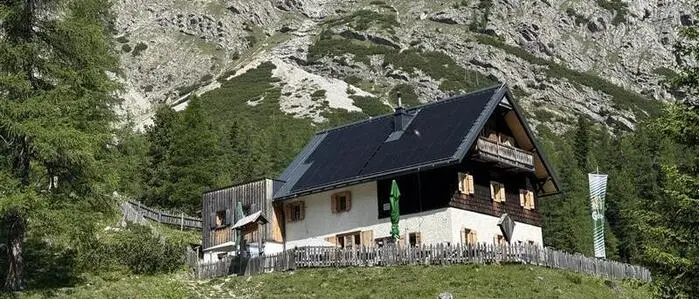 Das ÖTK-Schutzhaus auf der Kerschbaumeralm vor einer Felswand