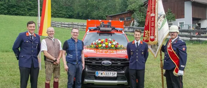 Fünf Männer vor einem Feuerwehrfahrzeug
