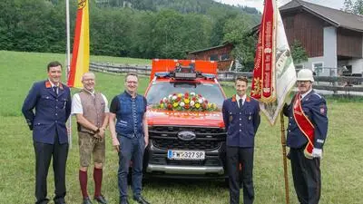 Fünf Männer vor einem Feuerwehrfahrzeug