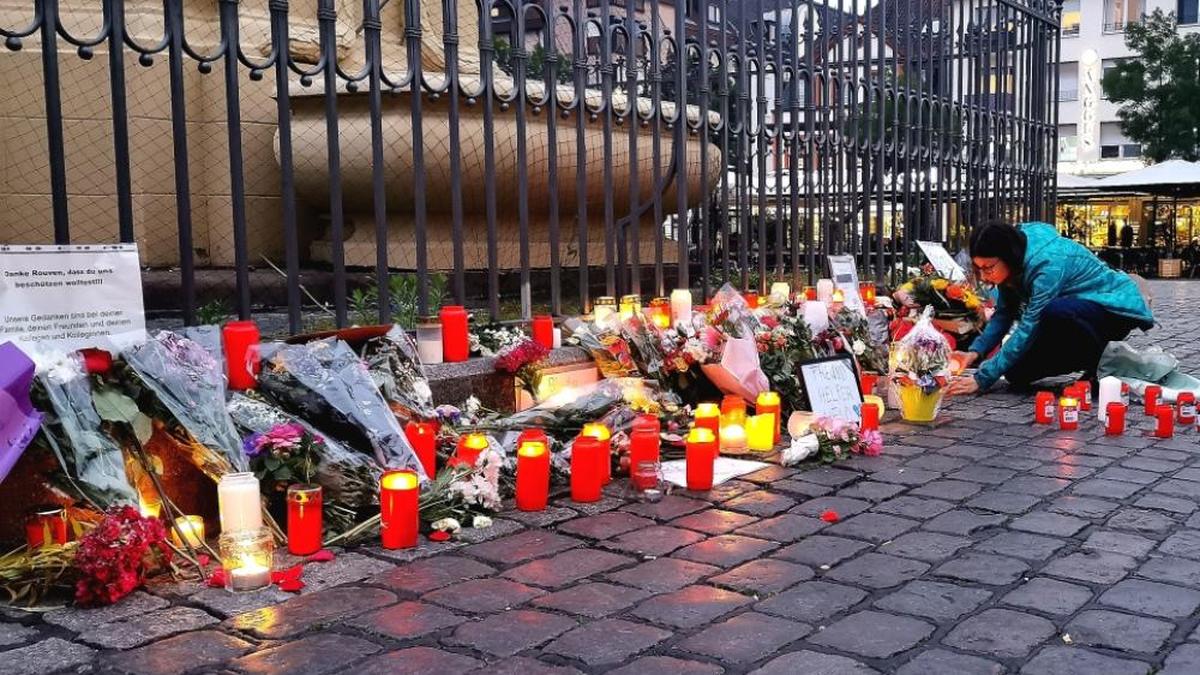 Baden-Württemberg, Mannheim: Nach dem Bekanntwerden vom Tod des Polizisten legen am Tatort am Marktplatz Passanten Blumen nieder und zünden Kerzen an. 