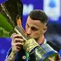 Inter Milan's Austrian forward #08 Marko Arnautovic (R) kisses the trophy during the ceremony for the Italian Champions following the Italian Serie A football match between Inter Milan and Lazio in Milan, on May 19, 2024. Inter celebrates his 20th Scudetto. (Photo by Marco BERTORELLO / AFP)