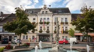 Am Bild sieht man das Rathaus Feldkirchen mit einem Brunnen im Vordergrund. 