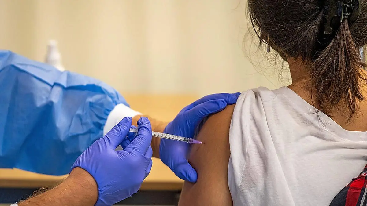 Zum Auftakt einer bundesweiten Impfaktionswoche hat Bundespraesident Frank-Walter Steinmeier am Montag 13.09.2021 eine Schule in Berlin besucht. Foto: Eine Schuelerin wird vom mobilen Impfteam in der Schule geimpft Steinmeier tauschte sich mit Schuelerinnen und Schuelern, Lehrerinnen und Lehrer sowie mit Aktiven eines mobilen Impfteams der Malteser aus, die in der Ruth-Cohn-Schule Vakzine gegen Covid-19 verabreichten. Dabei hob der Bundespraesident erneut die Bedeutung von Impfungen im Kampf gegen die Corona-Pandemie hervor. Die Ruth-Cohn-Schule ist ein Oberstufenzentrum fuer den Bereich Sozialwesen. Siehe epd-Meldung vom 13.09.2021 Impfaktion an Berliner Schule *** To kick off a nationwide vaccination week, German President Frank Wal Copyright: epd-bild/RolfxZoellner 