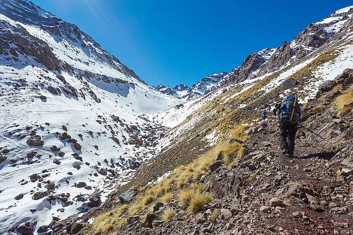 Das Klappern der Hufe hallt an den Berghängen wider. Mit den letzten Häusern endet auch die befestigte Straße und ein Wanderpfad tut sich auf - nach einer etwa zweistündigen Etappe haben wir dann unseren nächsten Stopp erreicht. Dort, wo der Schnee die Steine großflächig bedeckt, stehen ein paar Lehmhütten. Für unseren Esel ist hier Schluss, wir schultern das Gepäck.