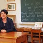 Kustodin Manuela Klaminger-Gruber am Lehrertisch der Waldschule
