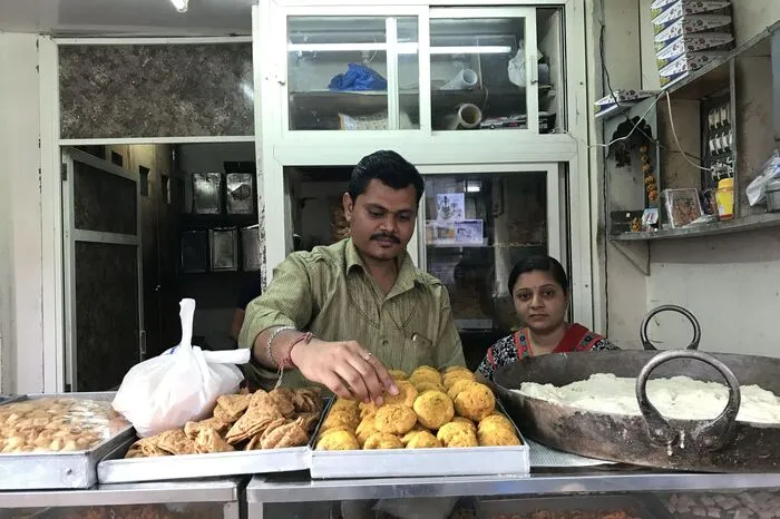 Auf den indischen Märkten, wie hier etwa in Bhuj, wird allerlei angeboten. Kulinarisch typisch für Gujarat sind süße Spezialitäten: frittiertes Linsenmehl oder runde, süße Bällchen aus Kichererbsenmehl.