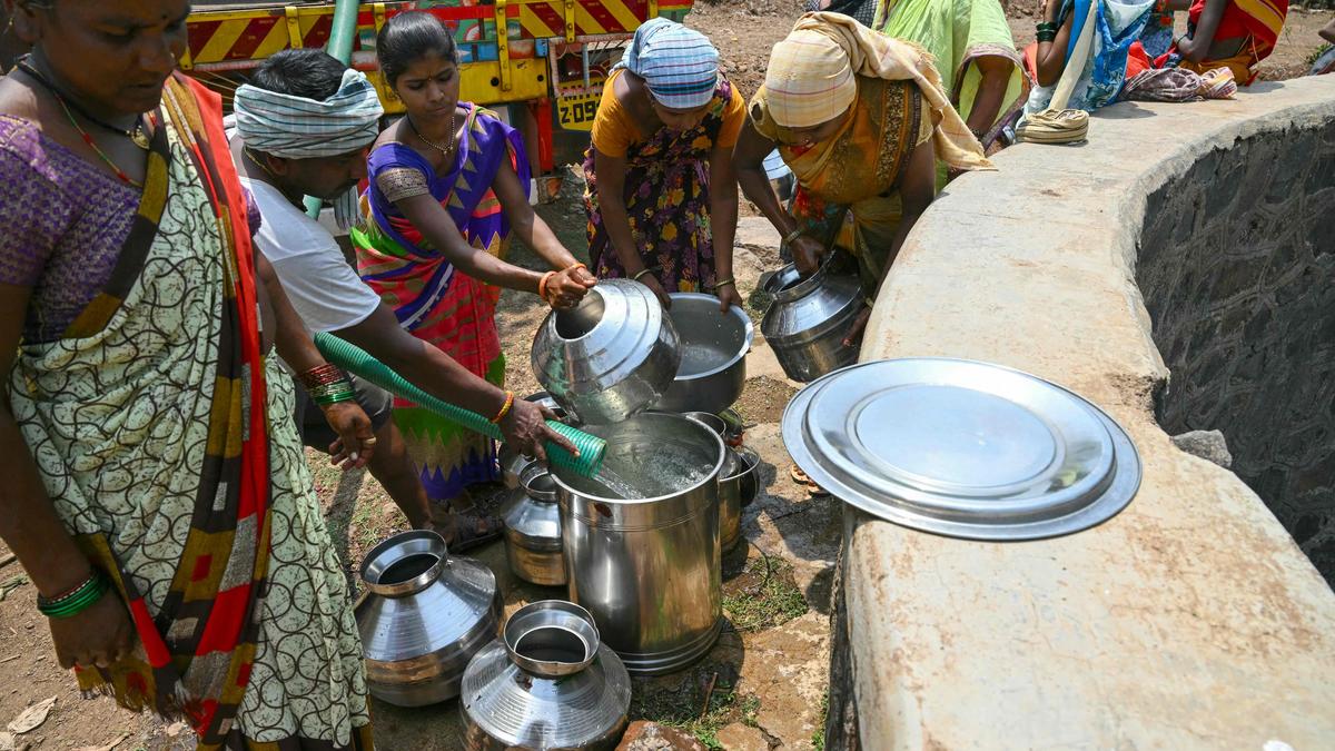 Dorfbewohnerinnen und Dorfbewohner sammeln Wasser während der Hitzewelle in Indien.