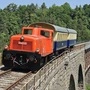 Die historische Diesellokomotive der Reihe 2026 zieht Waggons über eine Brücke