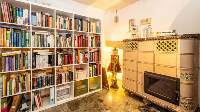 Die Stube mit Bibliothek und großem Kachelofen.