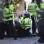 Police and medics attend to a person during a protest in Liverpool, England, Saturday Aug. 3, 2024, following the stabbing attacks on Monday in Southport, in which three young children were killed. (James Speakman/PA via AP)