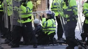 Police and medics attend to a person during a protest in Liverpool, England, Saturday Aug. 3, 2024, following the stabbing attacks on Monday in Southport, in which three young children were killed. (James Speakman/PA via AP)