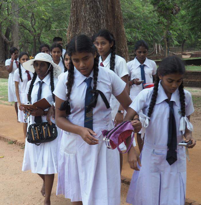 Schülerinnen in ihrer weißen Schuluniform besuchen die Ruinenstadt Polonnaruwa