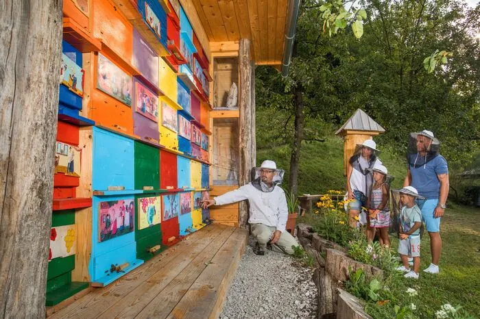 Bemalte Brettchen am Bienenhaus sind auch der Stolz der Imkerfamilie Ambrozic in Selo bei Bled, einem idyllischen Dörfchen mit unzähligen Streuobstbäumen auf grünen Wiesen. Blaz Ambrozic ist Profi-Imker und gibt sein Handwerk auch weiter, seine Frau Daniela ist Quereinsteigerin. „Wenn du mich liebst, musst du auch die Bienen lieben“, hatte er vor elf Jahren zu ihr gesagt und so war es auch gekommen.