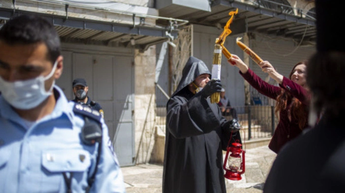 Ein Geistlicher hält das heilige Feuer vor der Grabeskirche in der Altstadt Jerusalems. Die Zeremonie des Heiligen Feuers ist in orthodoxen Ländern sehr wichtig. 