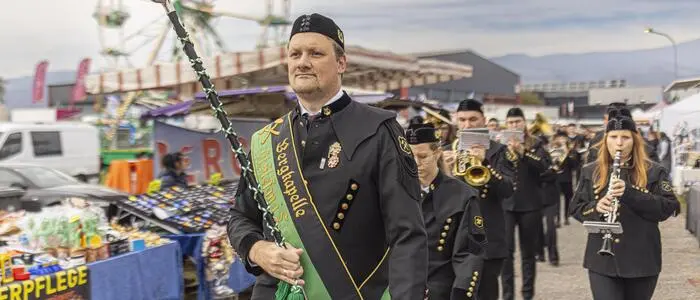 Musikkapelle beim Spielen, dahinter ein Riesenrad