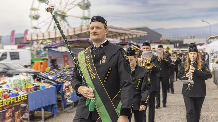Musikkapelle beim Spielen, dahinter ein Riesenrad