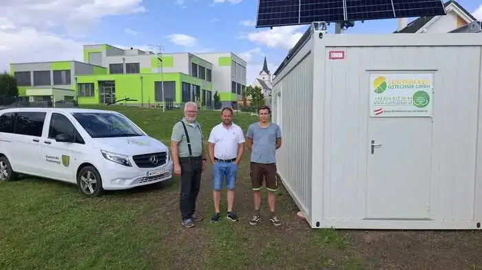 Drei Männer stehen vor einer Photovoltaik- Anlage