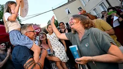 Bürgermeisterin Elke Kahr (KPÖ) am Sonntag bei der Wahlfeier im Volkshaus; sie grüßt ein Mädchen, das auf den Schultern eines Mannes (Neo-KPÖ-Gemeinderat Leo Kühberger) sitzt
