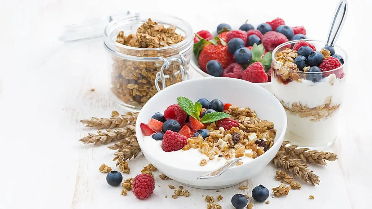 healthy breakfast with natural yogurt, muesli and berries and white background, horizontal