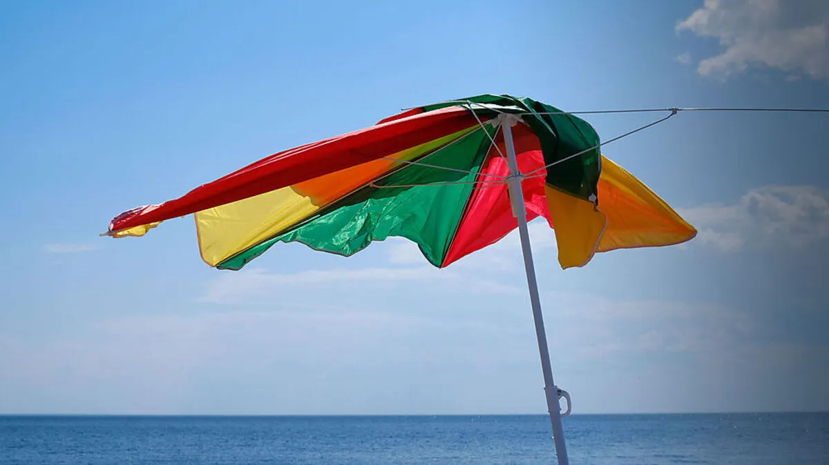 Von Windböe erfasst und durch die Luft gewirbelt: Sonnenschirm