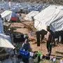 A migrant couple hang out their laundry outside their tent, in the new refugee camp of Kara Tepe, in the island of Lesbos, on December 19, 2020. (Photo by Anthi PAZIANOU / AFP)