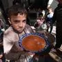 Palestinian children receive cooked food rations as part of a volunteer youth initiative in Rafah in the southern Gaza Strip, on March 5, 2024, amid widespread hunger in the besieged Palestinian territory as the conflict between Israel and the Palestinian militant group Hamas continues. (Photo by MOHAMMED ABED / AFP)