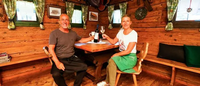 Franz und Manuele Ehepaar Erart sitzen in ihrem Lokal und prosten sich gegenseitig zu