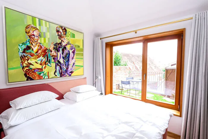 Das Besondere am Poolhaus: Es liegt direkt unter dem Freiluftpool am Hang des Schloßbergs und steht solitär mit einem kleinen Balkon mit Altstadt-Dächerblick. Man ist gefühlt hier ganz für sich. Das Zimmer ist mit 25 Quadratmetern nicht allzu groß, aber reizend.