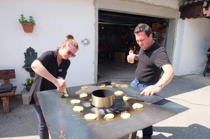 Karin Lidauer und Mario Zottler bereiten die Sättigungsbeilage zu: Erdäpfelpuffer von der Feuerplatte