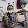 A young journalist receiving a shot of COVAXIN gestures to camera as she gets vaccinated against coronavirus at the press club in Gauhati, India, Wednesday, May 5, 2021. Vaccination for people of ages between eighteen and forty five in Assam state began Wednesday. (AP Photo/Anupam Nath)