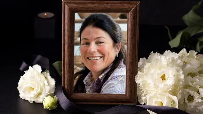 Ein von weißen Rosen und schwarzen Schleifen gesäumtes Bild einer Frau
