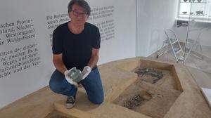 Museumsleiter Heinrich Kranzelbinder auf rekonstruiertem Grabhügel